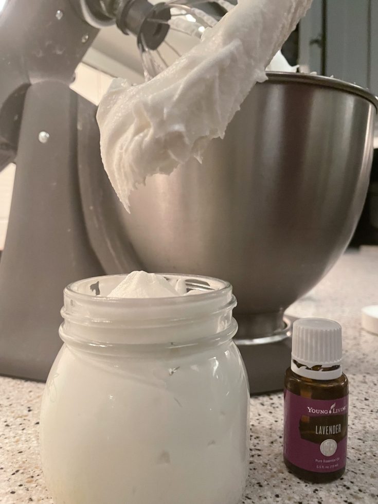 Tallow butter shown in a mixing bowl, storage jar and lavender essential oil