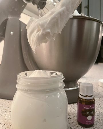 Tallow butter shown in a mixing bowl, storage jar and lavender essential oil